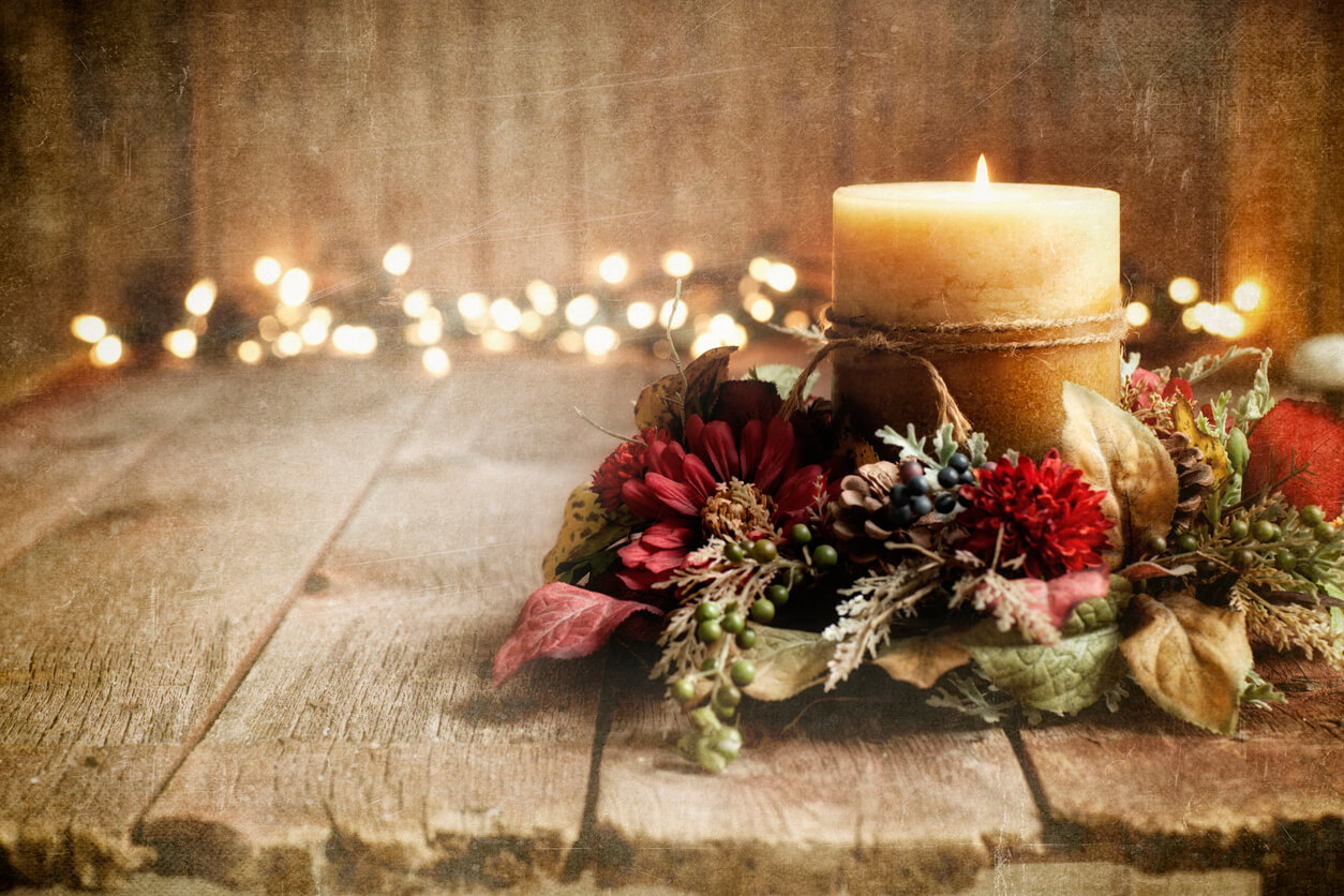 Christmas holiday candle on an old wood textured background