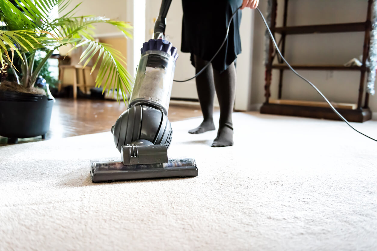 Woman vacuuming to clean her carpet